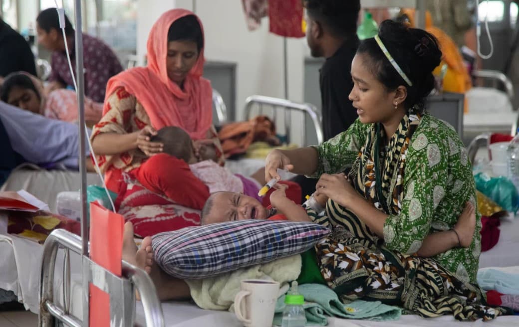 Bangladesh measles outbreak crisis showing overwhelmed hospitals, sick children receiving treatment, and healthcare workers during a nationwide vaccination emergency linked to public health system failures.