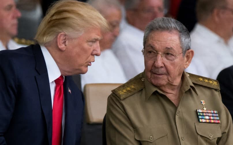 Former US President Donald Trump speaking with former Cuban leader Raúl Castro during an official diplomatic event, highlighting renewed US-Cuba political tensions and Cold War-era relations.